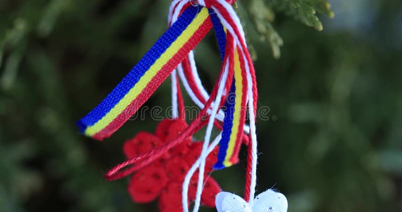 Martisor με τα ρουμανικά στοιχεία tricolor στο υπόβαθρο σύστασης χιονιού Μολδαβικό και ρουμανικό σύμβολο άνοιξη Το Martisor είναι